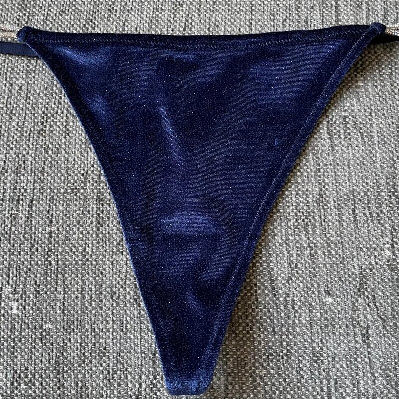 Ylellistä samettia ja säädettävää glamouria! Tummansiniset stringit, joissa kimaltelevat strassiyksityiskohdat.  Koko L.
