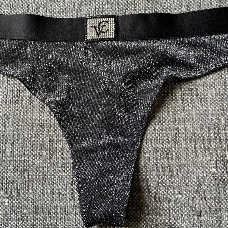 Glamouria arkeen kimaltelevalla tyylillä! Mustat stringit, joissa säihkyvä pinta ja logo vyötäröllä, koossa L.